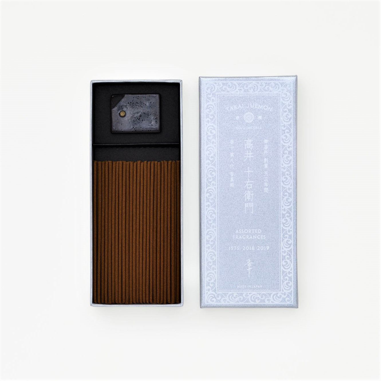 Open box of incense sticks with the lid beside it and a small incense holder visible.