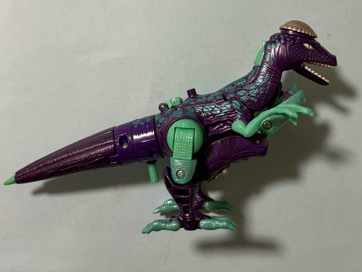 Purple and green Beast Wars Transformer figure (Hardhead) shown in dinosaur mode from the side on a plain background.
