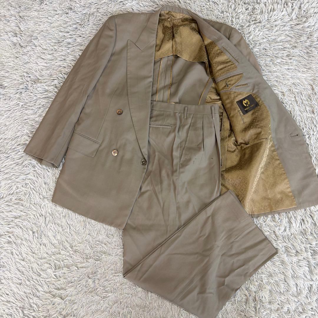 A double-breasted men's suit jacket and matching trousers laid flat showing the jacket's lining.