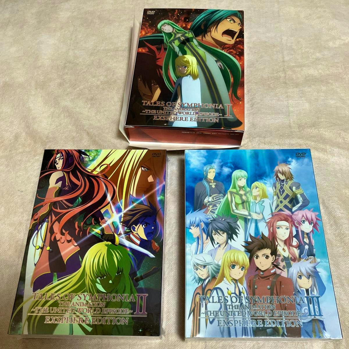 Three DVD volumes of テイルズ オブ シンフォニア THE ANIMATION テセアラ編 displayed on a cloth surface showing their cover art.
