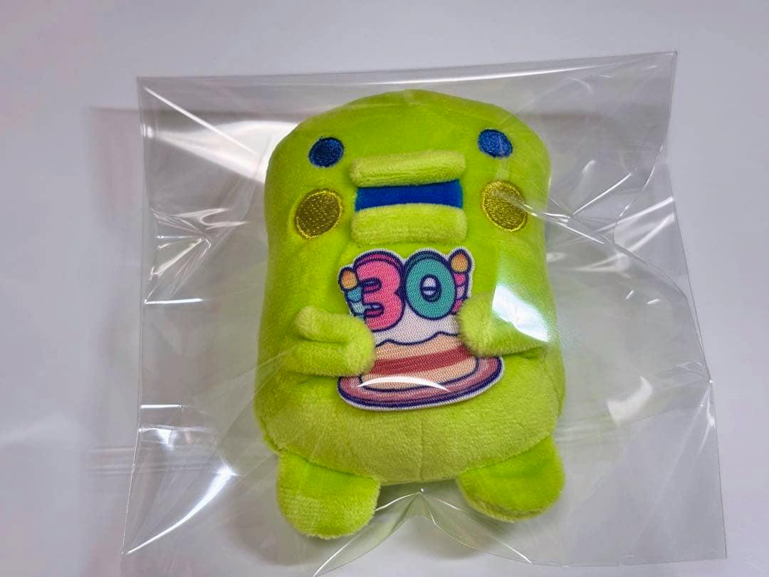 Green Tamagotchi Kuchipatchi plush inside a clear plastic bag on a white background.
