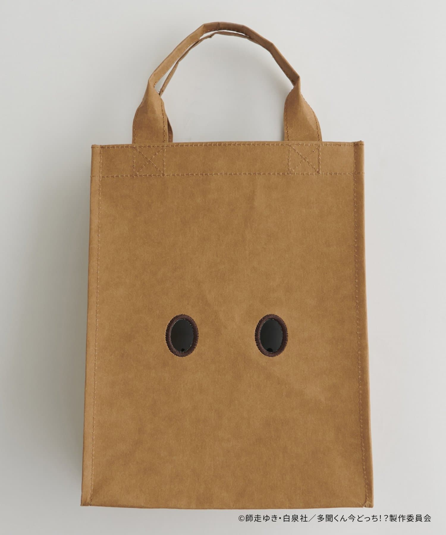 Brown paper-style tote bag with two round front holes and short handles.