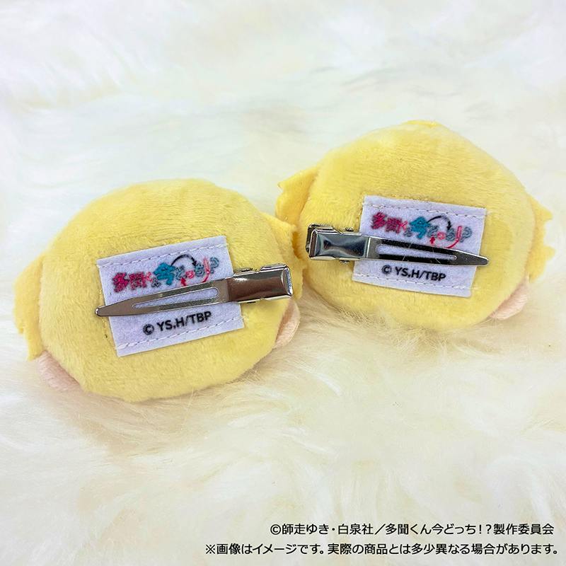 Back view of two yellow plush hair clips showing metal clips and sewn fabric tags.