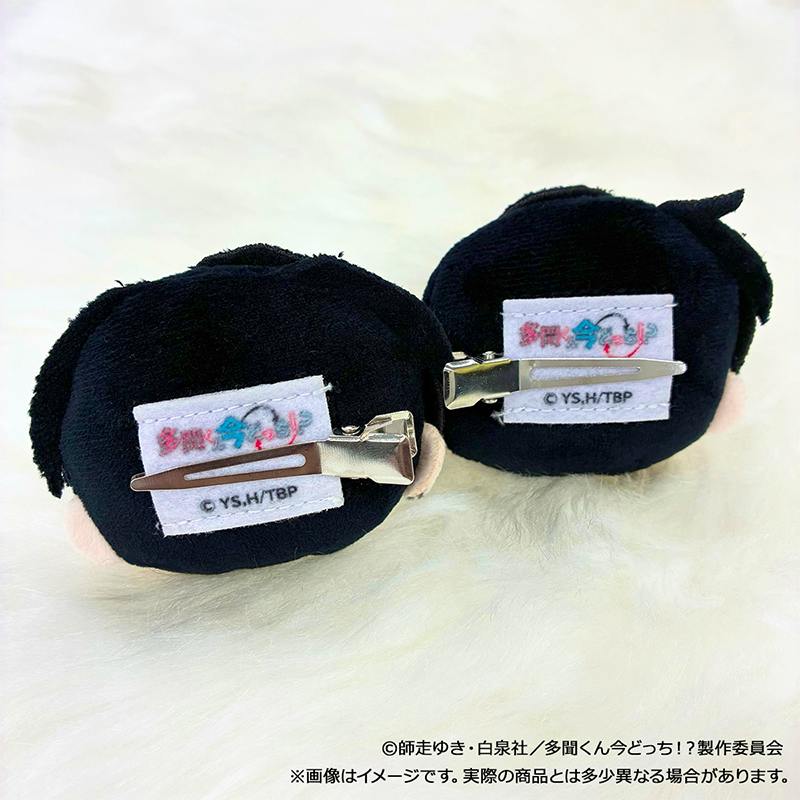 Two round plush character hair clips shown from the back, displaying their metal clip attachments.