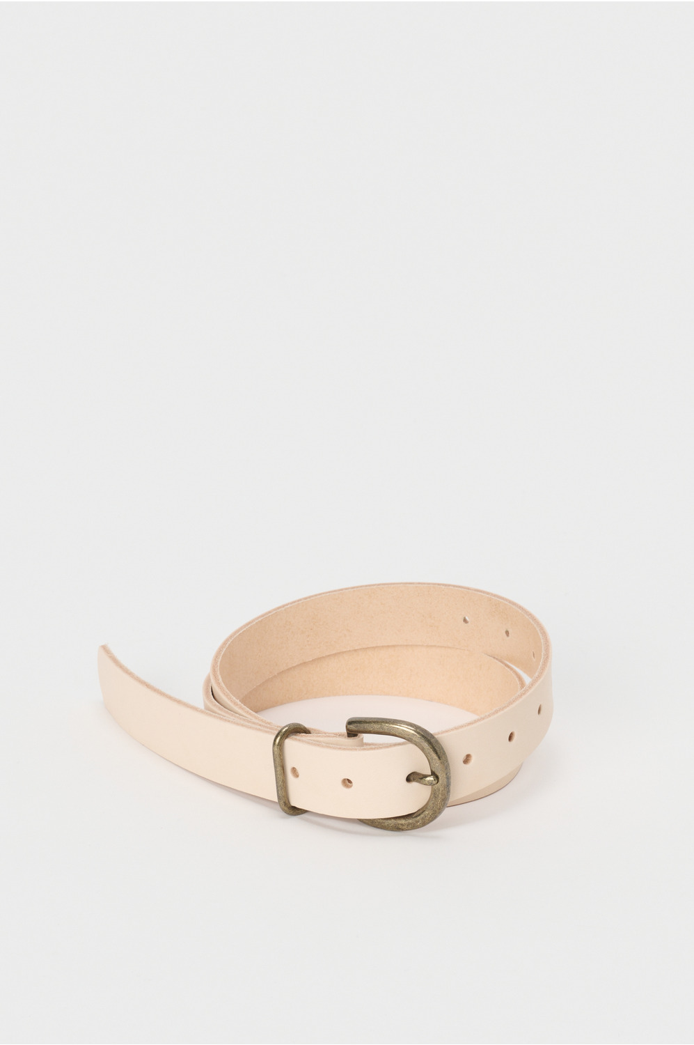Light tan cow leather tanning belt coiled with an oval brass buckle on a white background.