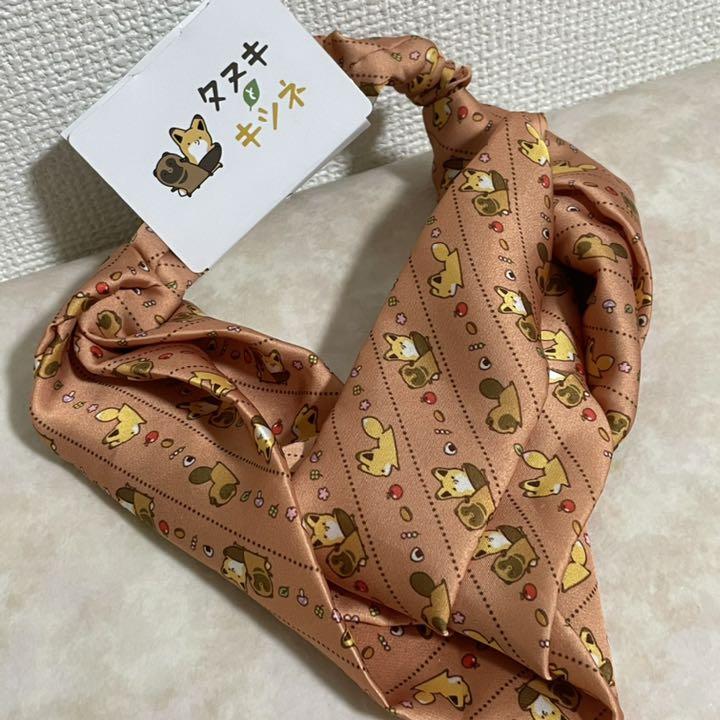 A patterned hair band featuring Tanuki and Kitsune character illustrations with an attached product tag.