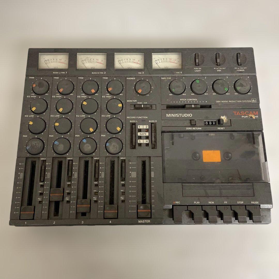 Top-down photo of the TASCAM PORTA ONE cassette multitrack recorder showing meters, knobs, faders, and the cassette compartment.