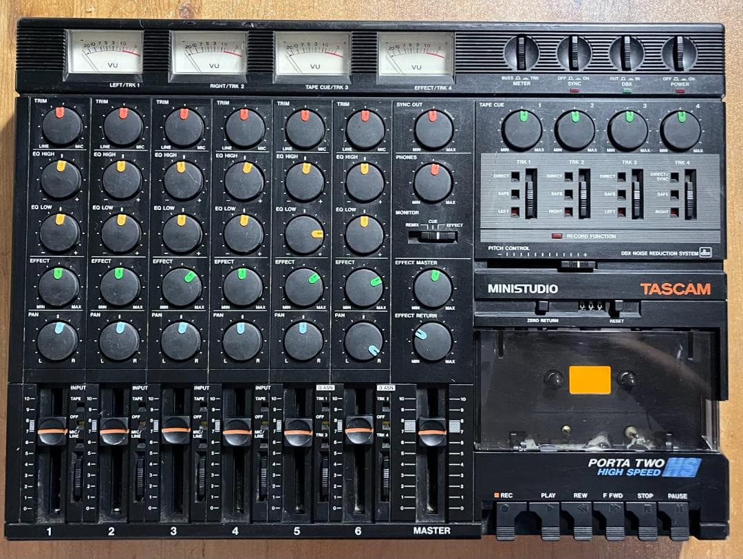 Top-down photo of a TASCAM PORTA TWO multitrack recorder showing VU meters, channel knobs and faders, and the cassette compartment.