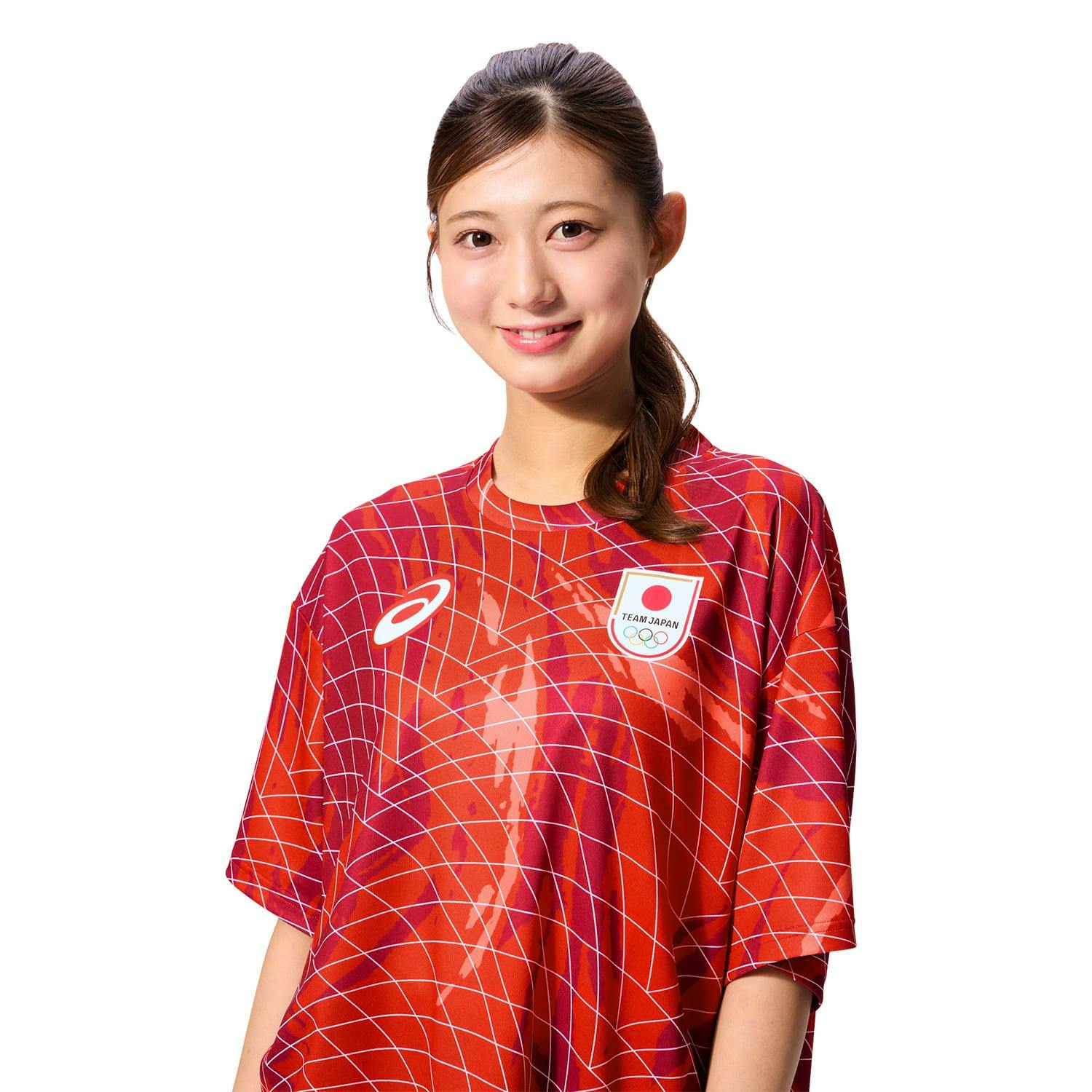 A model wearing the red TEAM JAPAN replica short-sleeve BIG silhouette support T-shirt with a white grid pattern, team crest, and Asics logo.