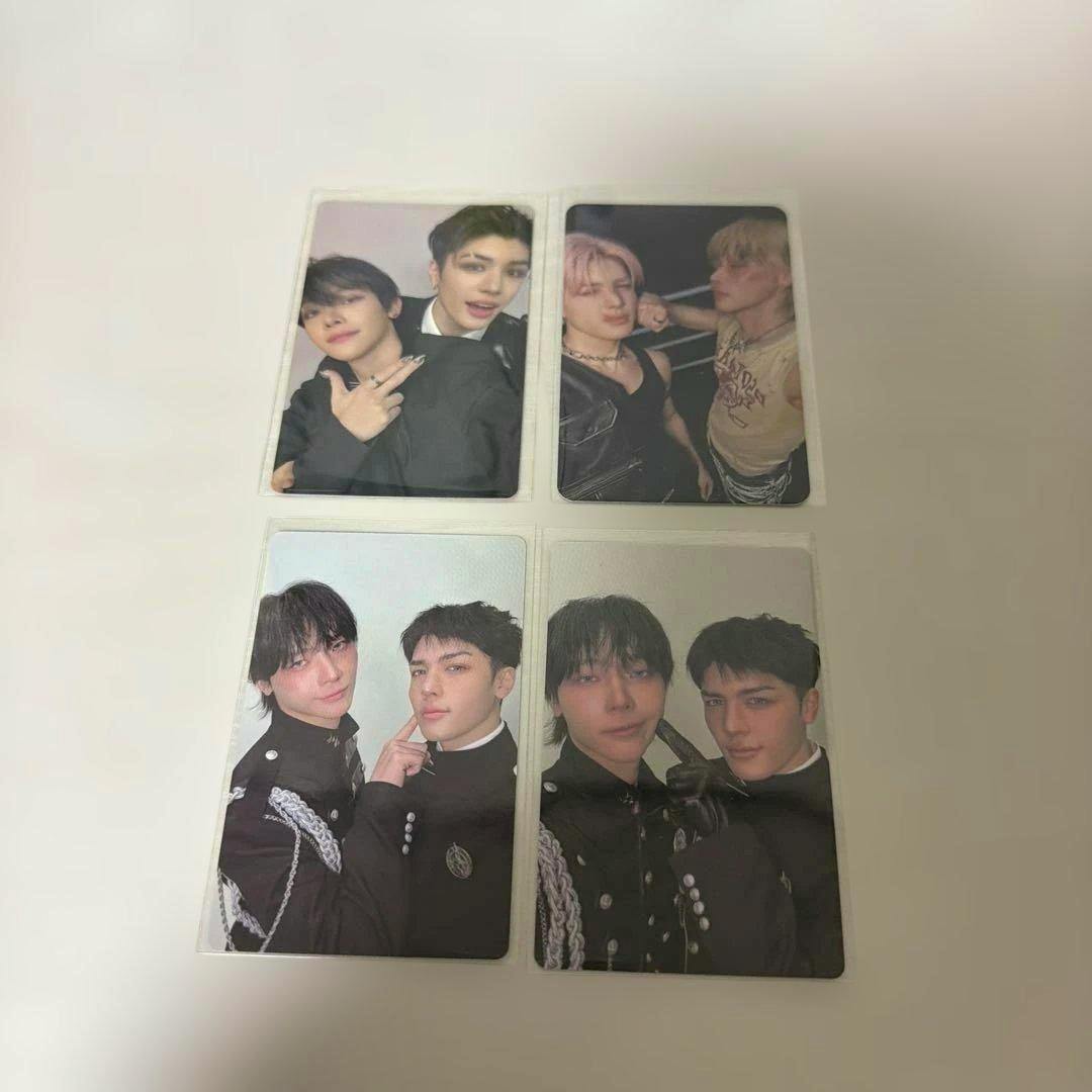 Four photocards showing people in portrait poses inside protective sleeves arranged on a white background.