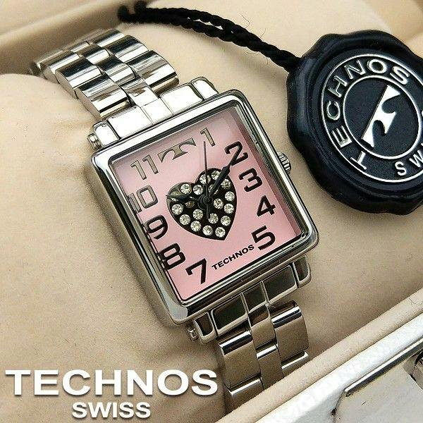 Square pink-dial women's Technos wristwatch with a crystal-studded heart motif and silver-tone metal bracelet displayed with a Technos tag.