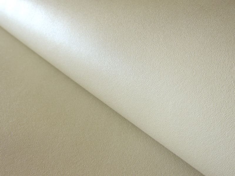 Close-up photo of light beige artificial leather fabric showing texture and moderate sheen.
