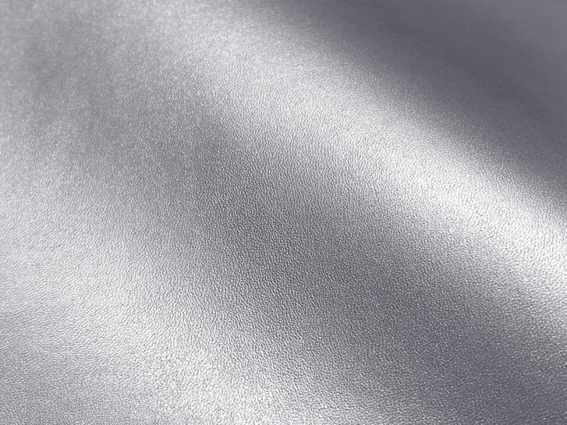 Close-up of silver artificial leather fabric showing its texture and metallic sheen.