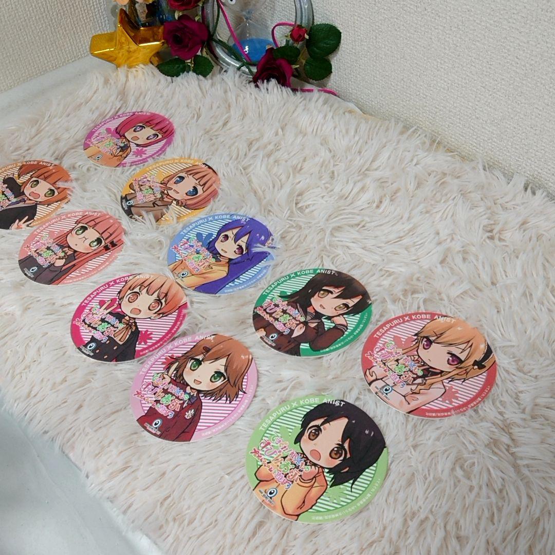 Multiple round paper coasters printed with chibi anime characters arranged on a white fluffy surface.