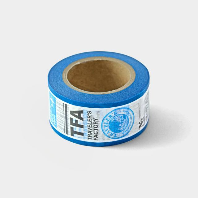 A roll of blue masking tape with a paper label showing the Traveler's Factory logo on a white background.