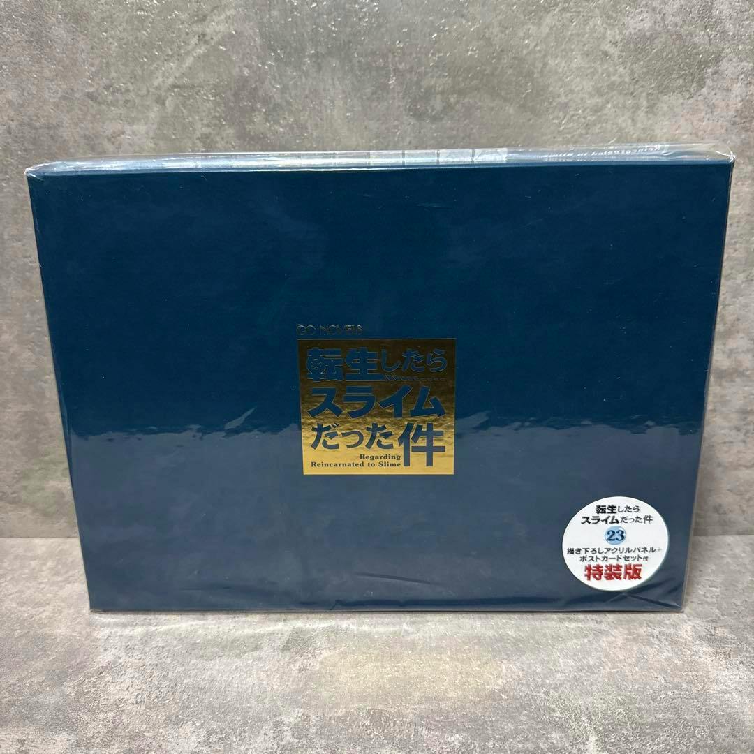 Front of the boxed special edition for 転生したらスライムだった件 volume 23 showing a dark blue box with a gold title emblem and a round white sticker.