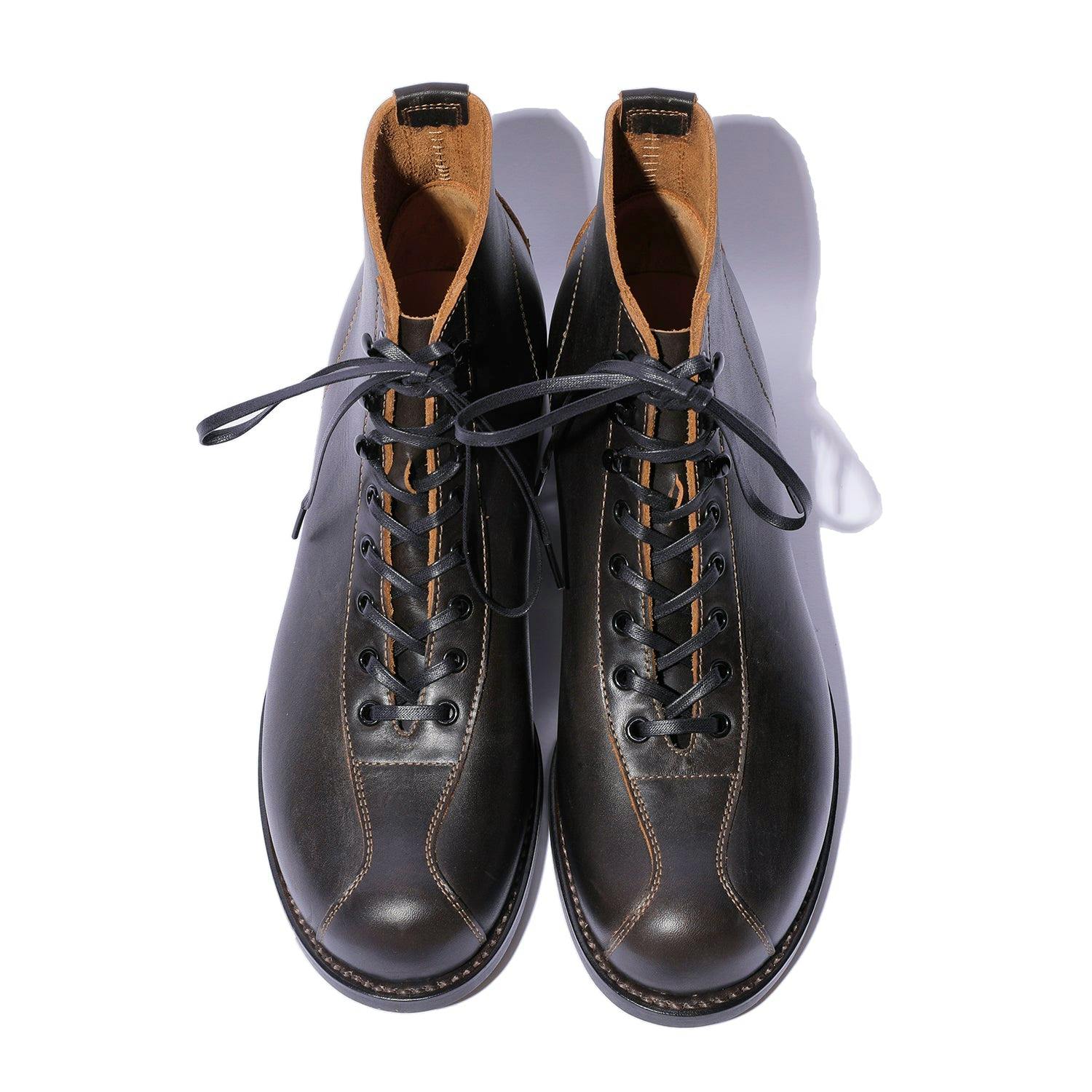 Top-down view of a pair of The 2 Monkeys RANDONNÉE gunmetal leather lace-up boots showing the toes, lacing, and interior collars.