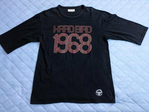 Black The Flat Head 5-sleeve cotton T-shirt laid flat showing a front "HARDBIRD 1968" print and small logo near the hem.