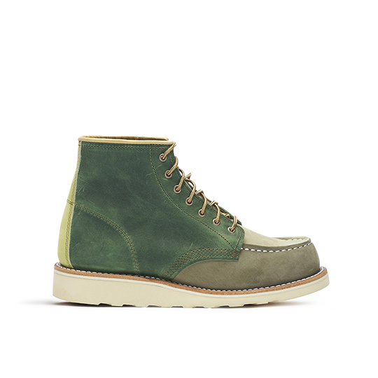 Side profile of a green leather boot against a black background.