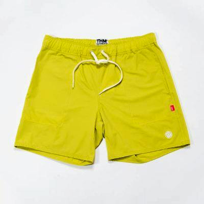 Front view of yellow men's polyester board shorts with an elastic waistband, drawstring, and a small logo on the left leg.