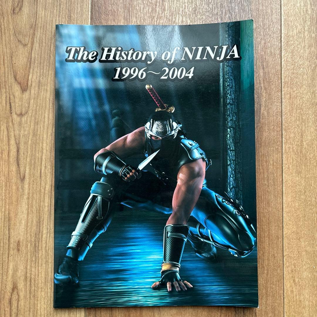 Front cover of the advertising catalog The History of NINJA 1996–2004 showing an illustrated crouching ninja on a wooden floor background.