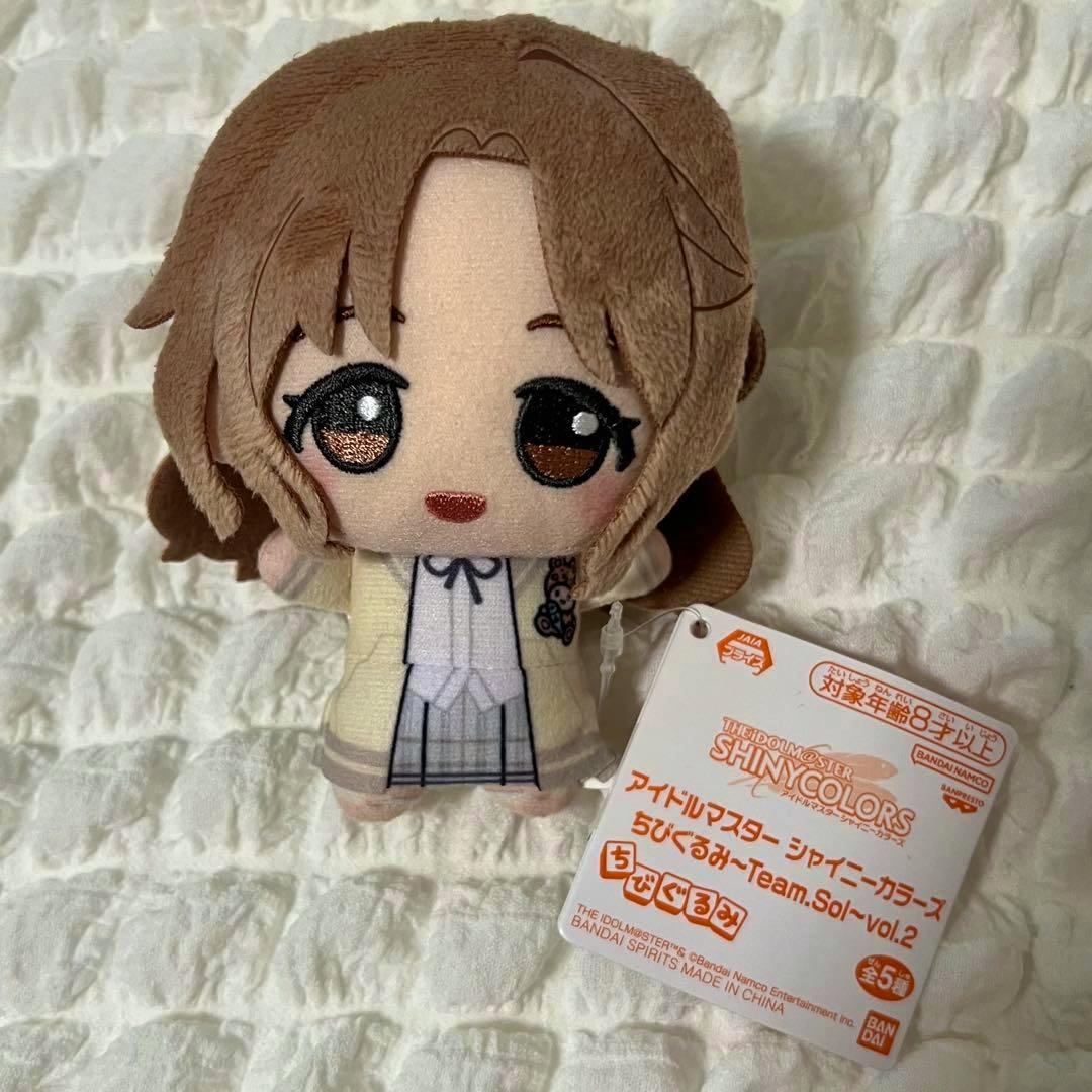 Front view of the アイドルマスター シャイニーカラーズ ちびぐるみ 市川雛菜 plush showing the embroidered face and attached product tag.