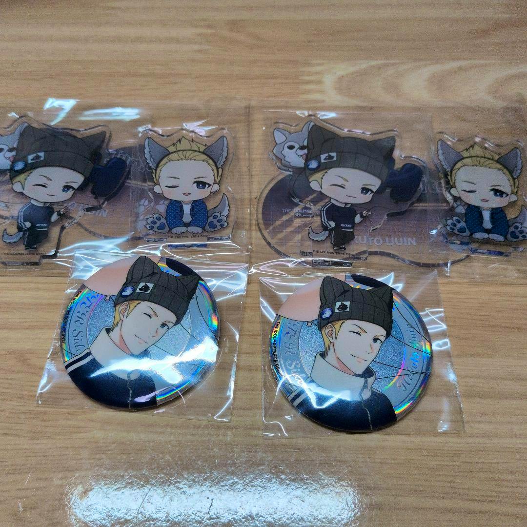 Acrylic chibi character stands and two round character badges arranged on a wooden surface, each sealed in plastic.