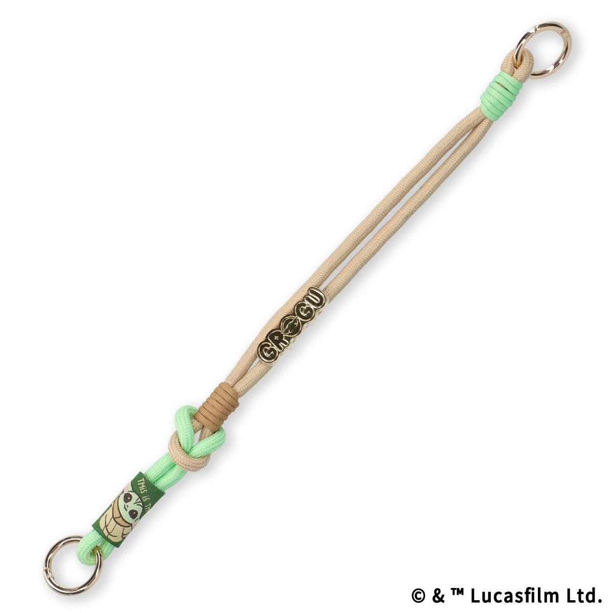 Beige and mint-green paracord hand strap for bags featuring a gold “GROGU” charm, Grogu fabric tag, and two metal O-rings.