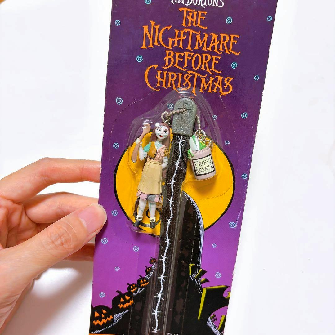 Packaged vintage The Nightmare Before Christmas Sally keychain strap showing a small Sally figure and a "Frog's Breath" charm on purple card backing.
