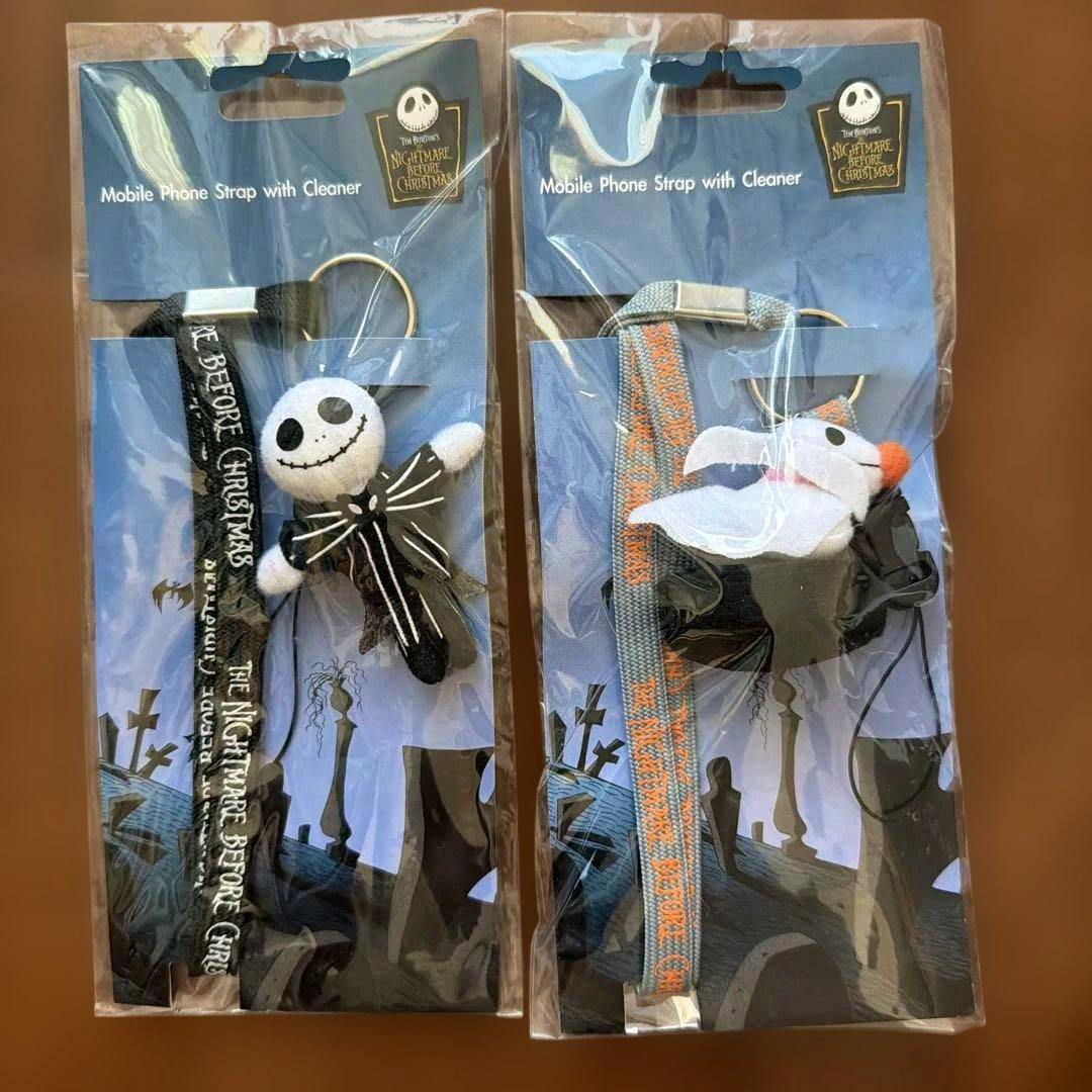 Two packaged Nightmare Before Christmas mobile phone straps with plush character charms shown side-by-side.