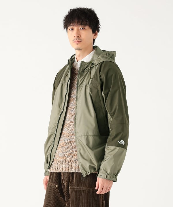 Male model wearing an olive green THE NORTH FACE PURPLE LABEL Mountain Wind Parka in a front three-quarter view.