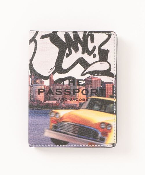 Front view of a passport-style wallet showing a city skyline and a yellow vintage car graphic with the words "THE PASSPORT" on the front.