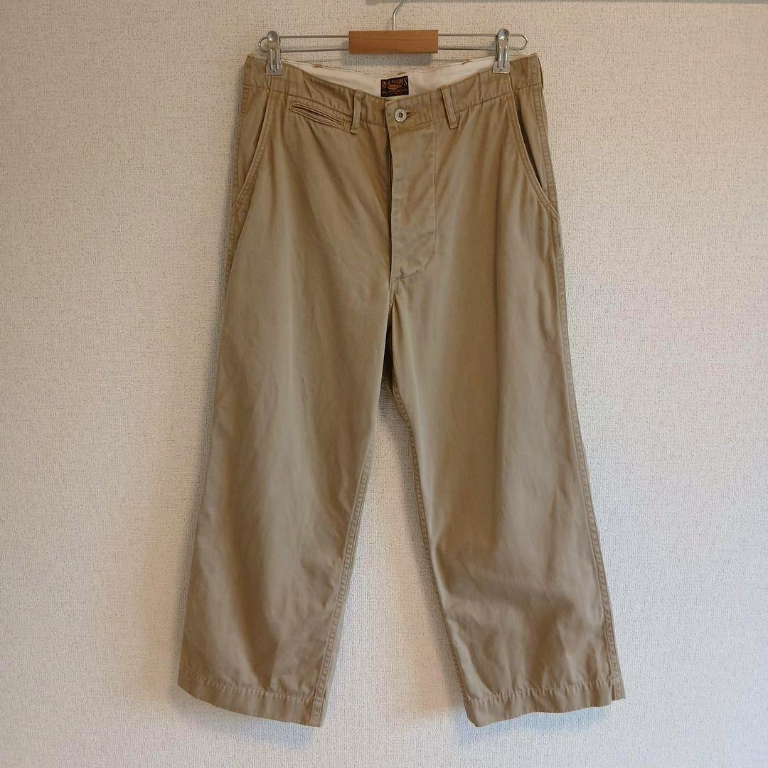 Front view of khaki cotton men's trousers (Real McCoy's, W32) hanging on a hanger.
