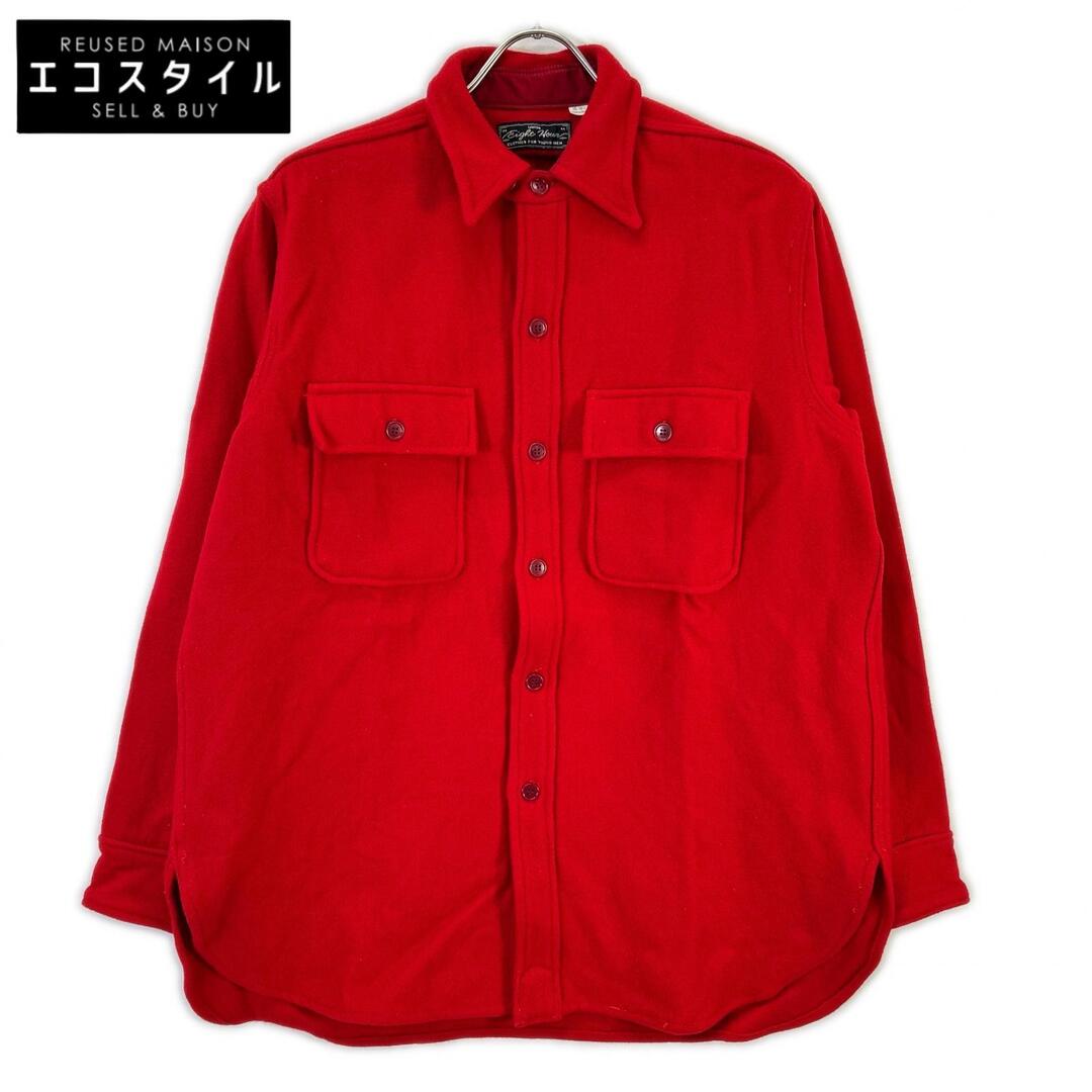 Red wool CPO-style shirt with two flap chest pockets hanging on a hanger against a white background.