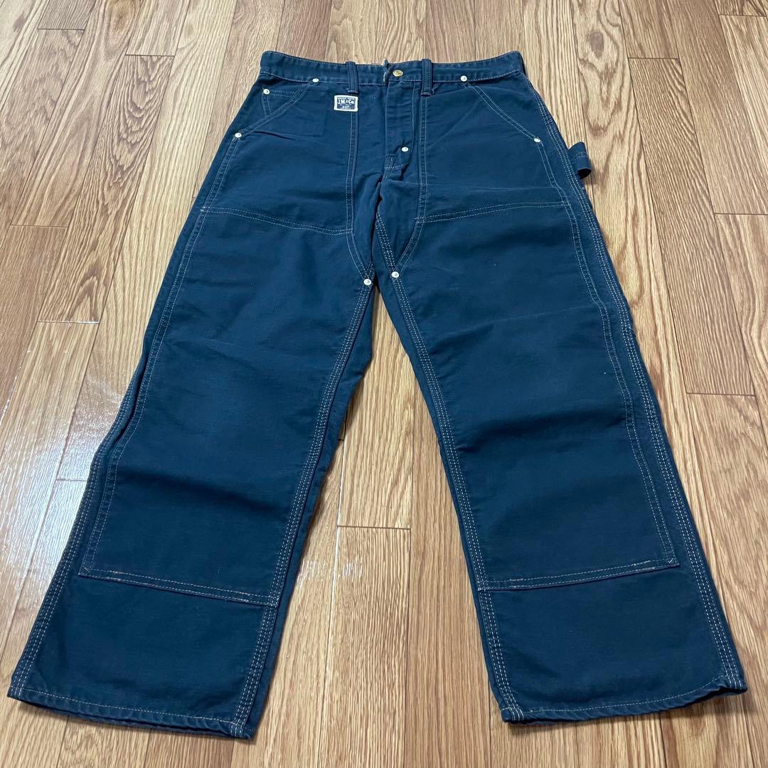 Navy Real McCoy's double-knee painter men's cotton pants laid flat on a wood floor showing the full front view.
