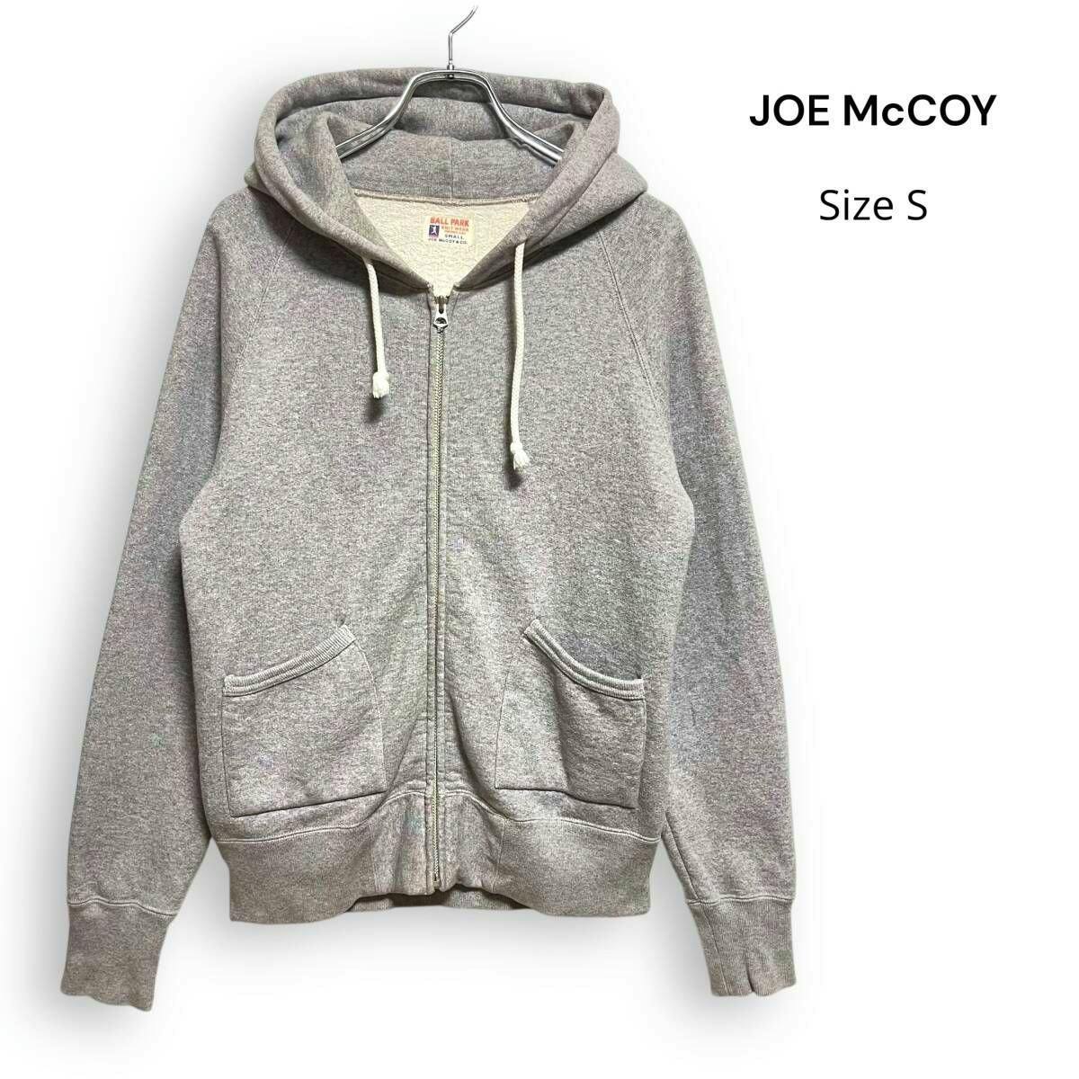 Gray Joe McCoy zip-up hooded sweatshirt (Size S) hanging on a hanger, front view showing drawstrings and front pockets.