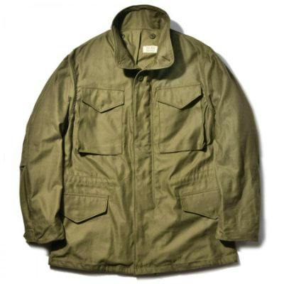 Front view of an olive-green M-65 early model men's cotton field jacket showing four front flap pockets and a high stand collar.