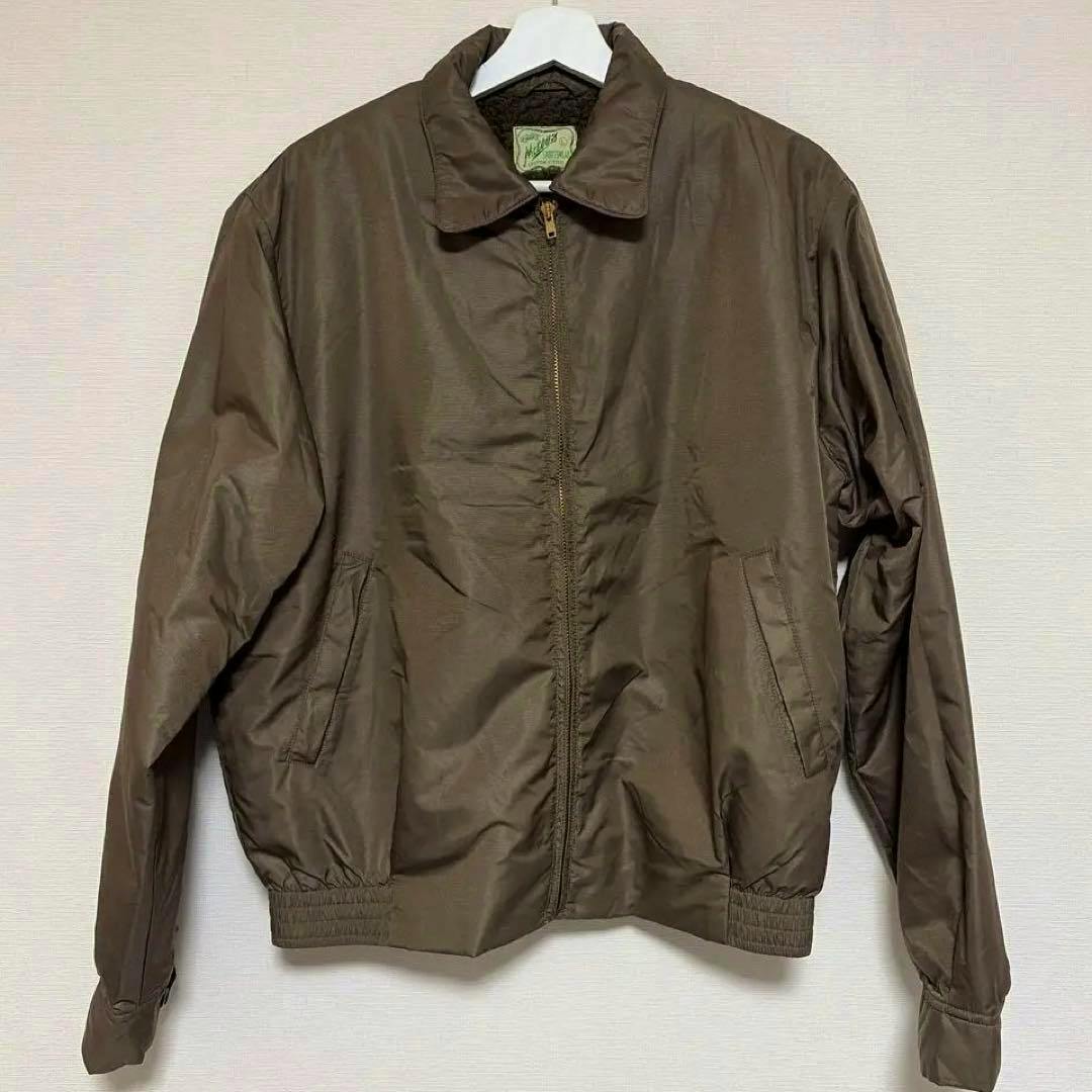 Brown nylon men's swing-top jacket hanging on a hanger, front view with zipper closed.