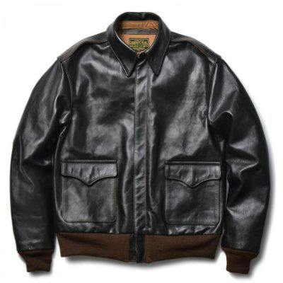 Front view of a black patent leather Type A-2 jacket laid flat showing two front flap pockets and ribbed hem and cuffs.