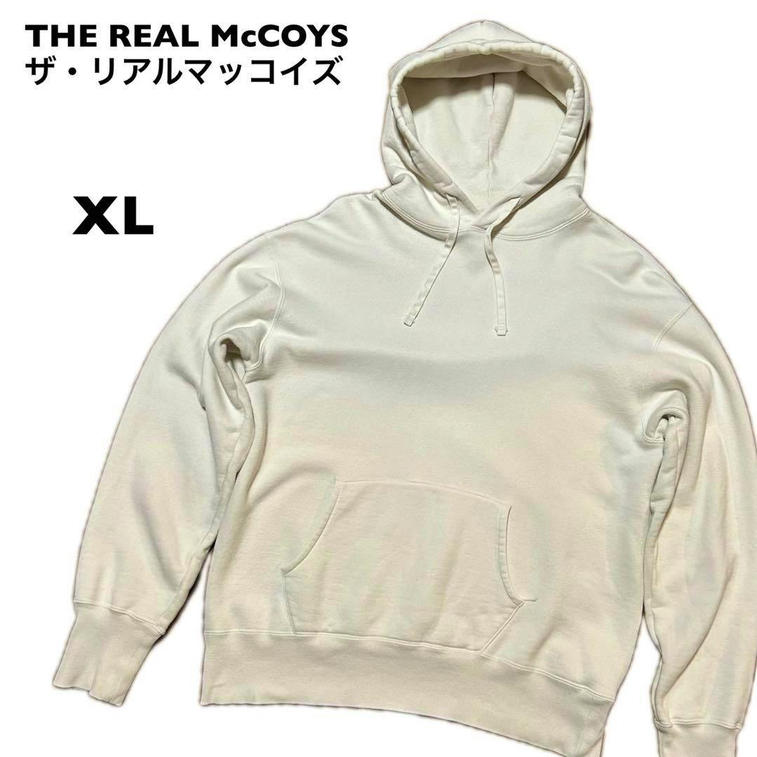THE REAL McCOYS cream-colored men's cotton sweatshirt hoodie laid flat showing the front, hood with drawstrings, and a kangaroo pocket with 'XL' text visible.