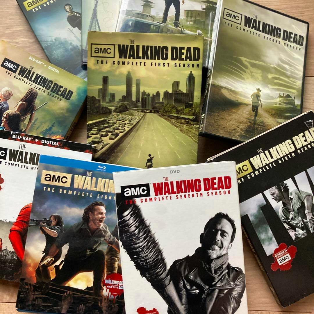 Multiple The Walking Dead DVD/Blu-ray season box sets laid out on a floor, showing several season covers.