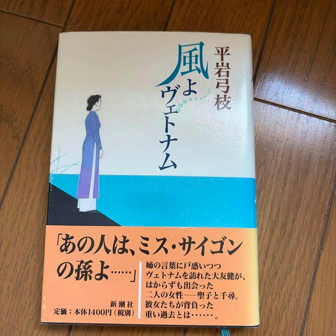 Front cover of the book showing the Japanese title 風よヴェトナム, an illustration of a woman in a blue dress, and an orange obi band at the bottom.