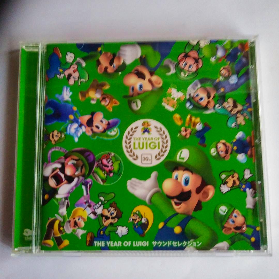 Front of THE YEAR OF LUIGI CD in a jewel case showing green Luigi-themed cover art with multiple Luigi illustrations.