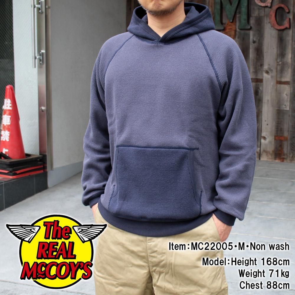 A model wearing the thermal two-tone hooded sweatshirt with a front kangaroo pocket, front view.
