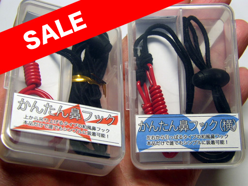 Two plastic nose hooks, one black and one red, shown in clear plastic cases.