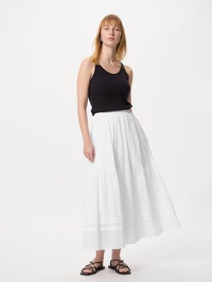 Model wearing a white tiered maxi skirt shown full-length.