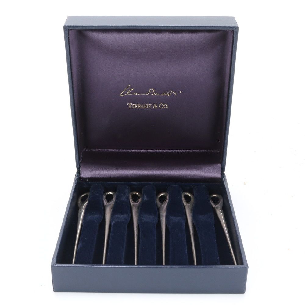 Open Tiffany & Co. box showing six cocktail picks seated in a blue velvet insert.
