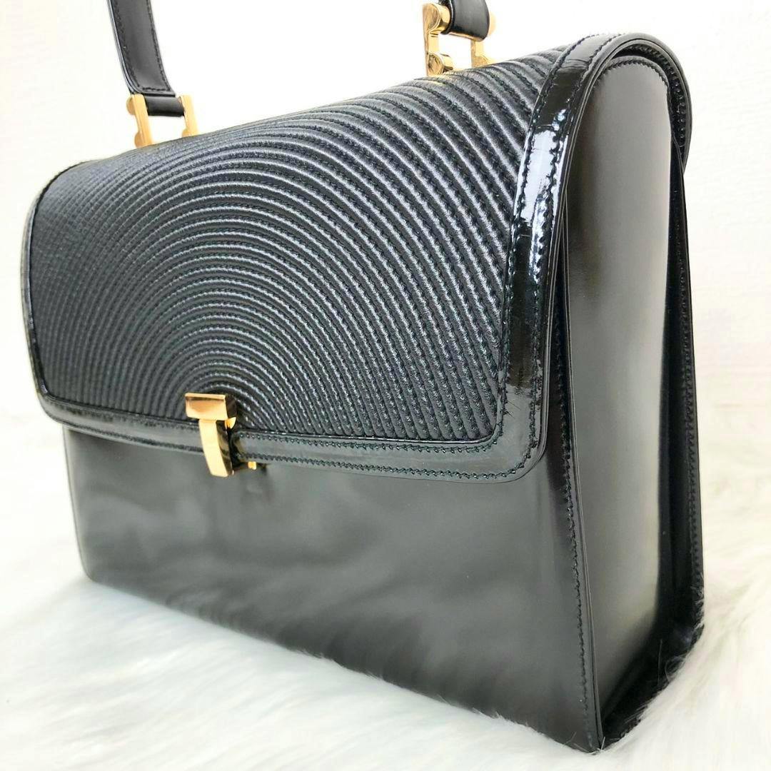 Black Tiffany vintage handbag (cow leather) with a textured curved flap and gold T-lock, shown at a side angle.