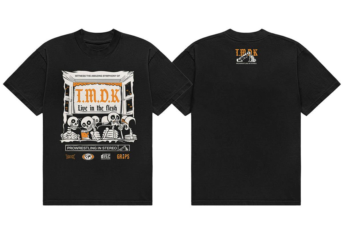 Front and back of a black TMDK "LIVE IN THE FLESH" cotton T-shirt showing a printed skeleton concert graphic on the front and a small logo on the back.