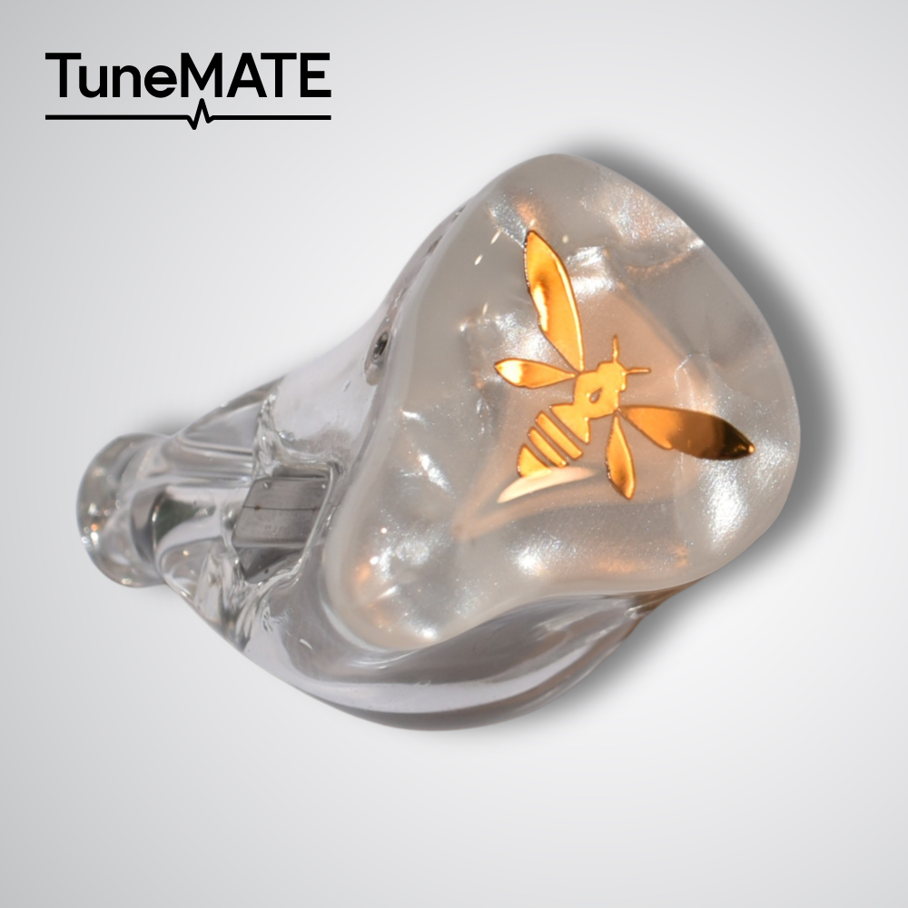 Close-up of a clear wired earphone earpiece showing a gold bee logo.